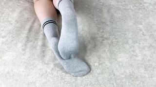 Solo caressing girl in gray cotton socks on the sofa